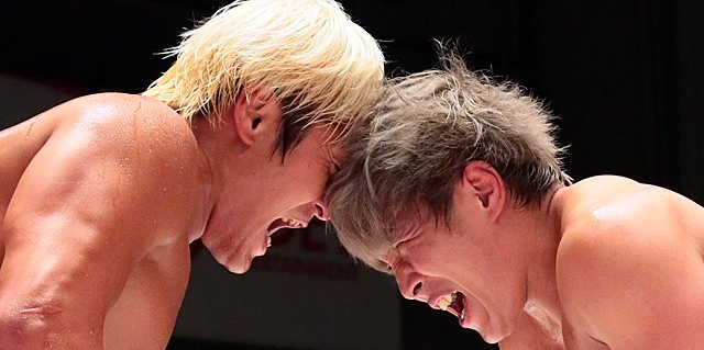 Kenoh and Haoh in a match, pressing their foreheads against each other and screaming