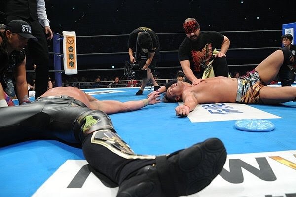 Kenny and Okada, collapsed in the ring after a match