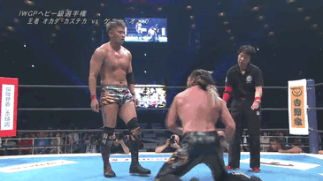 Gif from the match of Kenny on his knees, striking at a defiant Okada standing in front of him