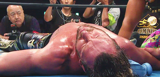 Gif of Kenny and Okada, collapsed after match. Kenny reaches out for Okada with one hand. 