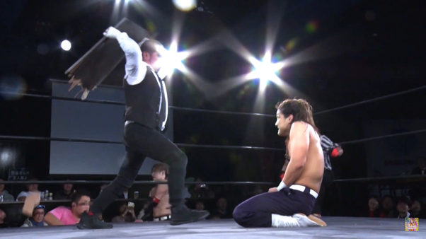 Jun Kasai about to hit Ikemen Jiro over the head with a table mid-match