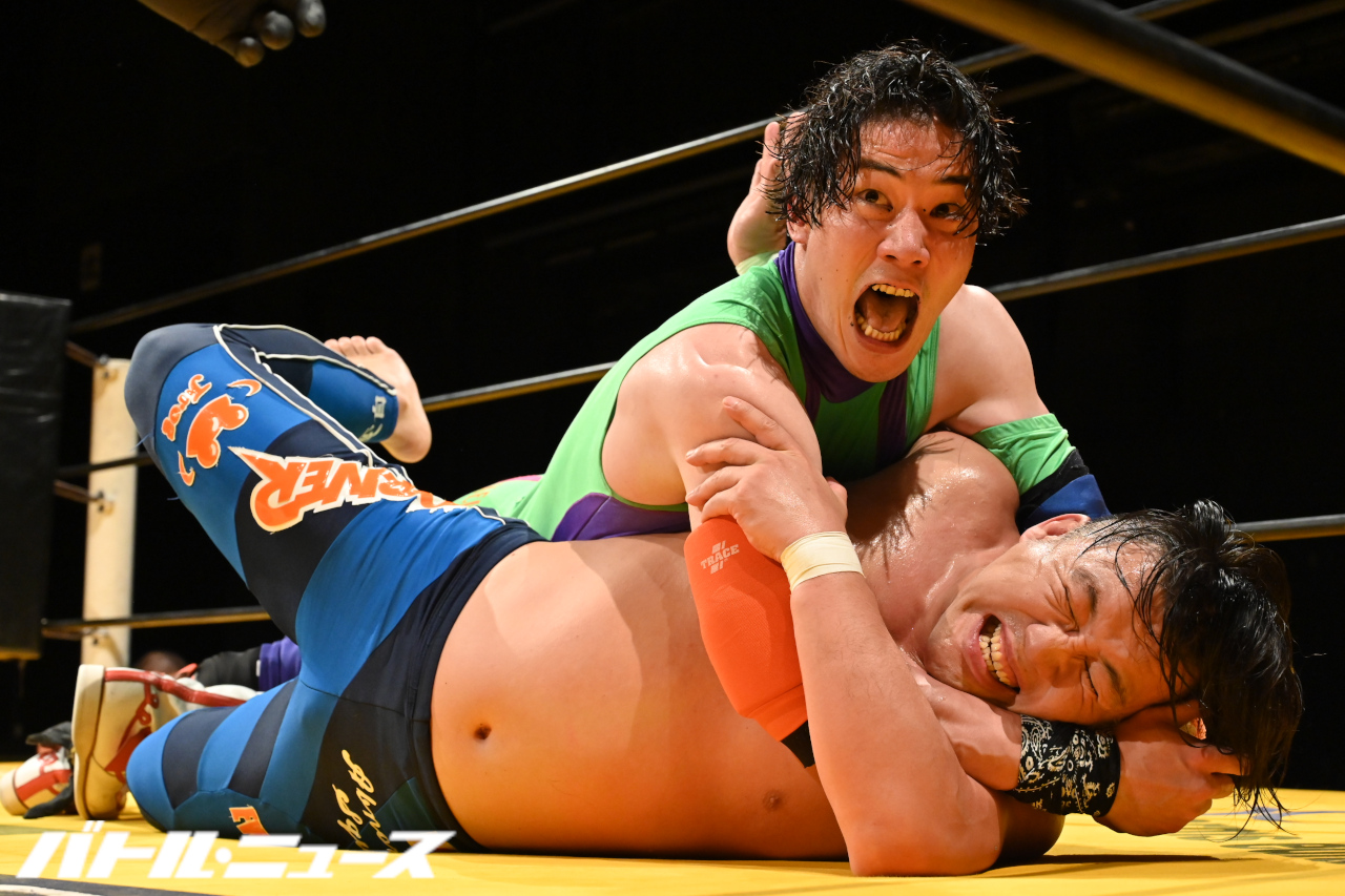 Yano, screaming, holds Hikaru Sato in a modifed face lock.